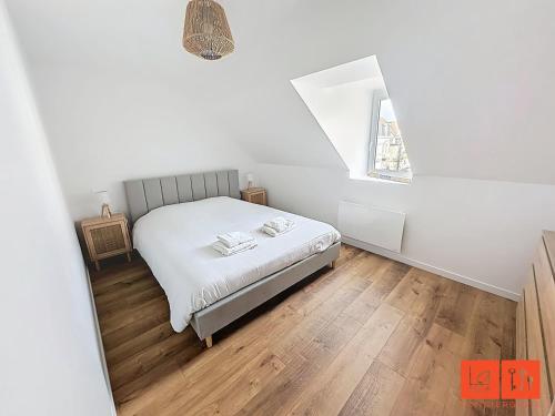 une chambre blanche avec un lit et une fenêtre dans l'établissement La Grande Augustine, à Wimereux