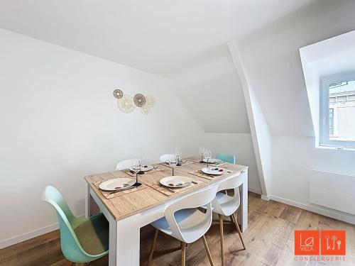 une salle à manger blanche avec une table et des chaises dans l'établissement La Grande Augustine, à Wimereux