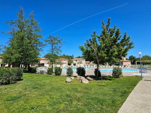 un groupe de rochers dans l'herbe près d'une piscine dans l'établissement Villa 7 personnes résidence Mélody, à Santa-Maria-Poggio