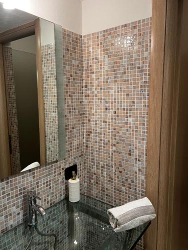 a tiled bathroom with a sink and a mirror at Rossi Lake Couple in Oliveto Lario