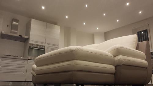 a living room with a white couch in a kitchen at Peri Peri Holiday Home - Siracusa in Solarino