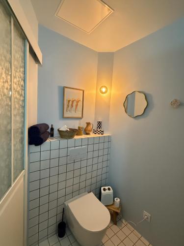 une salle de bain avec des toilettes blanches et un miroir dans l'établissement Appartement ARTY avec patio, à Nîmes