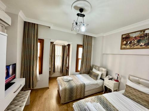 une chambre d'hôtel avec deux lits et une télévision dans l'établissement Rosalie Palace, à Istanbul