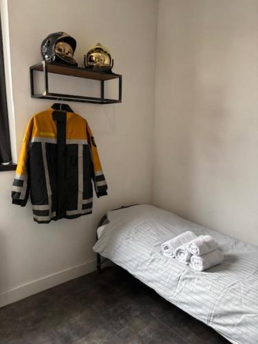 a bedroom with a bed and a shelf with a jacket at De Oude Brandweerkazerne 2 tot 4 persoons 2 kamer appartement in Kaatsheuvel