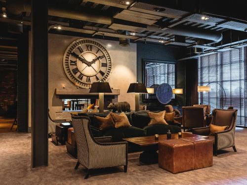 a living room with a large clock on the wall at Dakota Eurocentral in Motherwell