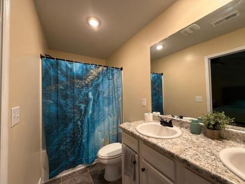 une salle de bain avec un rideau de douche bleu et des toilettes dans l'établissement 3bed townhouse in McDonough GA, à McDonough