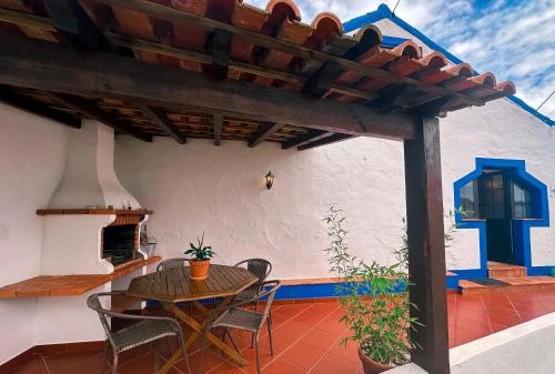 a patio with a table and chairs on a house at Quinta da Fonte - Casa da Charrete in Caldas da Rainha