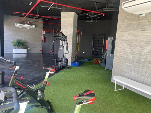 une salle de sport avec des vélos d'exercice et un mur en briques dans l'établissement Betania Plaza Premium, Piso17 - BY INMOVE TEMPORARIOS, à Córdoba