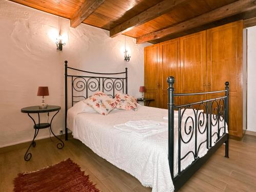 a bedroom with a black bed and a table at Quinta da Fonte - Casa da Charrete in Caldas da Rainha