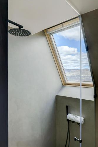 a bathroom with a shower with a window at TheVagar - Glamping Mountain Shelters in Belmonte
