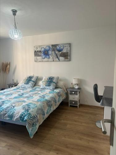 une chambre avec un lit avec une couette bleue dans l'établissement Apparemment Vias plage-village, à Vias