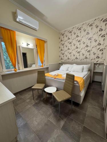 a bedroom with a bed and two chairs and a table at Szem-s Vendégház in Balatonszemes
