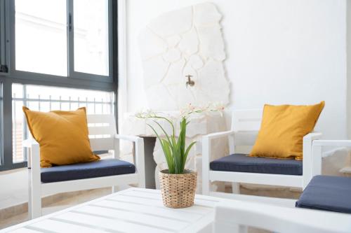 a room with two white chairs with yellow pillows at 5 stelle Dimora storica in Valle D'Itria con WIFI in Turi