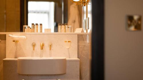 a bathroom with a white sink and a mirror at Europa Hotel in Belfast