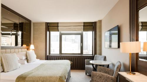 a hotel room with a bed and a table and chairs at Europa Hotel in Belfast