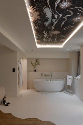 a bathroom with a bath tub and a dragon painting on the ceiling at MiHotel Le Gourguillon in Lyon