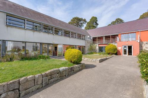 an external view of a building with a stone wall at Knockree Hostel in Enniskerry