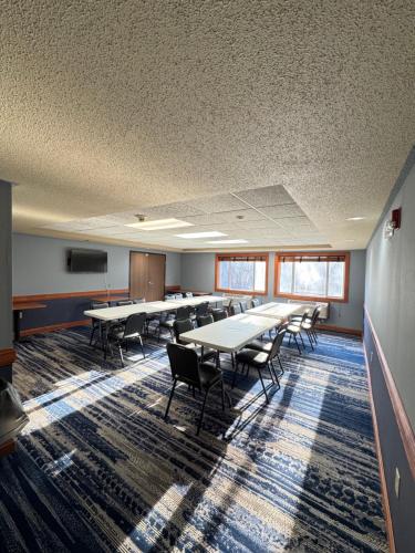 a conference room with tables and chairs and a tv at AmericInn by Wyndham Baldwin in Baldwin