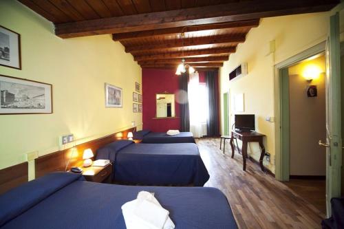 Habitación con 2 camas y escritorio con ordenador. en Hotel San Lorenzo, en Florencia