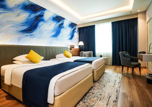 En eller flere senge i et værelse på Mövenpick Grand Al Bustan