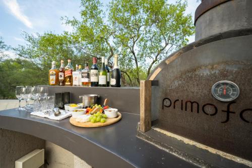 a table with a plate of food and bottles of wine at The Baobab Bush Lodge and Villa in Hoedspruit