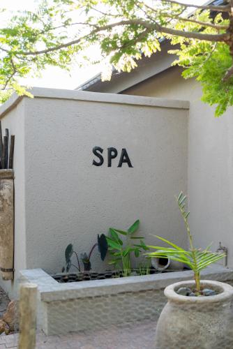 a spa sign on the side of a building with plants at The Baobab Bush Lodge and Villa in Hoedspruit