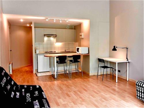 une cuisine avec une table et des chaises dans une pièce dans l'établissement Vue sur le Vieux Port, à La Rochelle