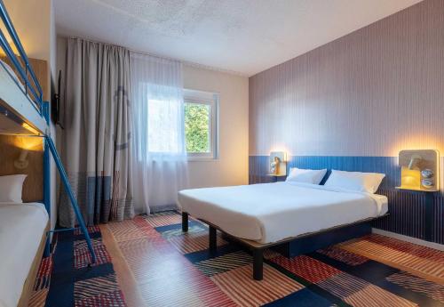 une chambre avec un grand lit blanc et une fenêtre dans l'établissement B&B HOTEL Saint-Pierre-en-Faucigny Bonneville, à Saint Pierre en Faucigny