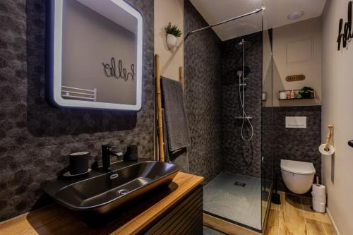 un bagno con un lavandino nero e una doccia di Le Temple du Désir - Intimité & plaisir - HyperCentre a Rouen