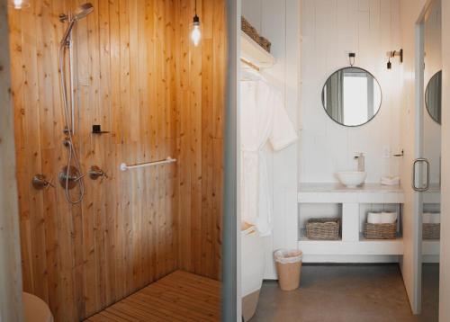 a bathroom with a shower with a wooden wall at La Petite Bûche #1 in La Malbaie