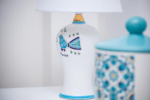 a bottle on a shelf next to a vase at Lolly Apartment in Alghero