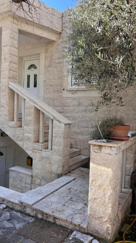 a stone house with a staircase and a stair case at Beachfront Four Bedroom Apartment in Sveti Stefan
