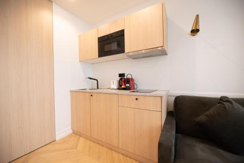 une cuisine avec un évier et un micro-ondes dans l'établissement Flat by River & Bastille, à Paris