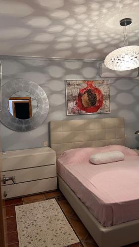 a bedroom with a pink bed and a mirror at Beachfront Four Bedroom Apartment in Sveti Stefan