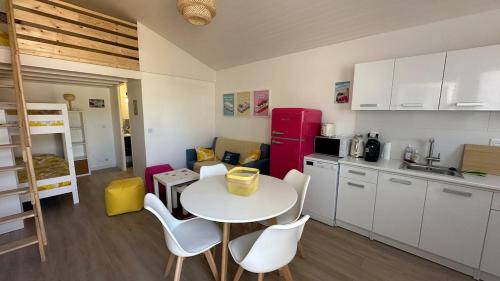 une cuisine avec une table et des chaises dans une pièce dans l'établissement Maison de vacances à proximité de la plage à pieds, à La Celle-sous-Gouzon