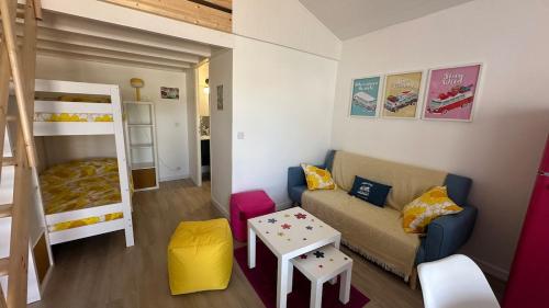 - un salon avec un canapé et des lits superposés dans l'établissement Maison de vacances à proximité de la plage à pieds, à La Celle-sous-Gouzon