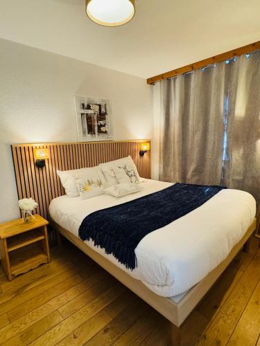 une chambre avec un grand lit et une fenêtre dans l'établissement Appartement Vu Mont Blanc parking Terrasse, à Chamonix-Mont-Blanc