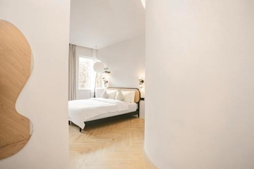 a white bedroom with a bed and a window at EUPHORIA丨Quiet Garden Quiet Designer Garden Hotel丨Datang Never Sleeps City Big Wild Goose Pagoda Subway Station Branch丨Near the scenic area in Xi'an