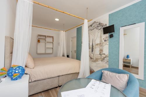 a bedroom with a bed and a couch and a table at O Quintal Guesthouse in Carvoeiro