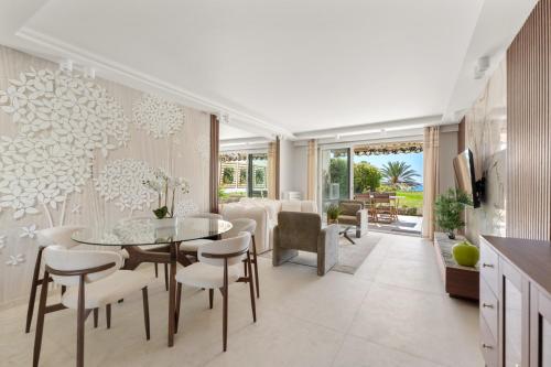 une cuisine et une salle à manger avec une table et des chaises dans l'établissement Luxueux Appartement avec Jardin Suspendu Vue Mer 10 min du Palais Cannes, à Cannes