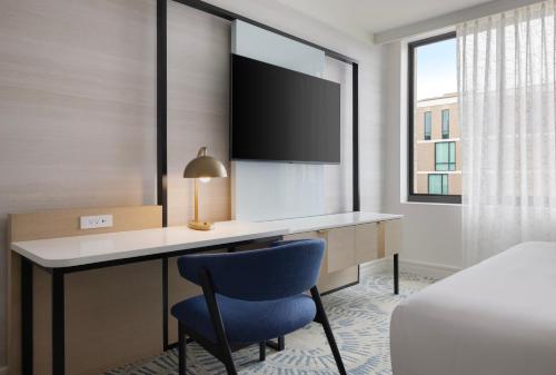 a hotel room with a desk and a blue chair at The Highland Dallas, Curio Collection by Hilton in Dallas