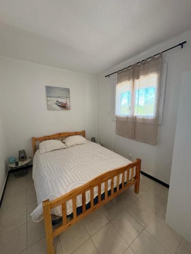 une chambre avec un lit et une fenêtre dans l'établissement Appartement proche de la plage, à Argelès-sur-Mer