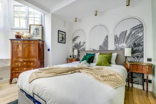 une chambre avec un grand lit et une commode dans l'établissement Le Jardin d'Hiver - Superbe et lumineux Studio, à Paris
