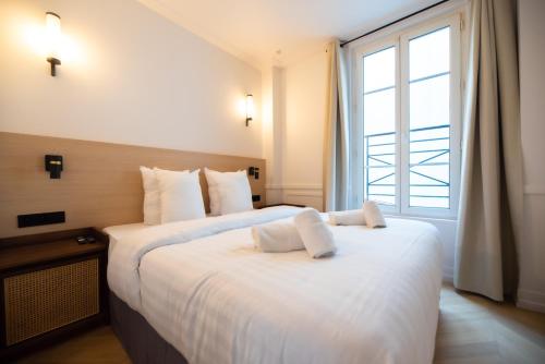 deux lits dans une chambre d'hôtel avec une fenêtre dans l'établissement Austerlitz & Bastille's Home, à Paris