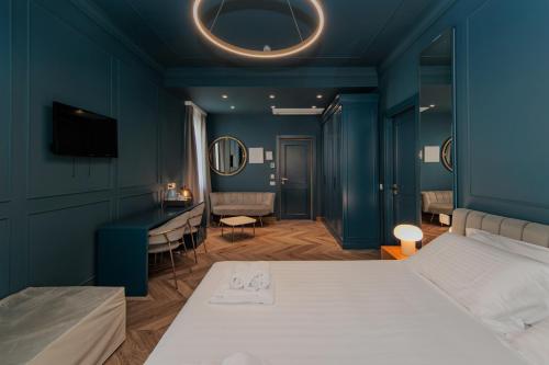 a bedroom with blue walls and a bed and a desk at OPHELIA Hotel in Cazzago San Martino