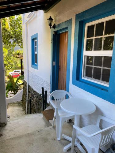a white table and chairs outside of a house at Casas Aguas Cantantes in Ubatuba
