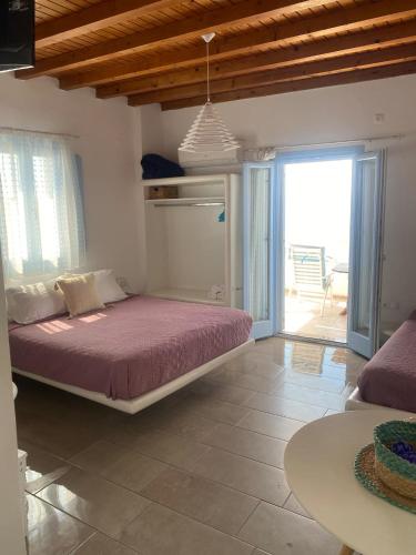 a bedroom with a large bed and a patio at Studios Betty in Plaka Milou