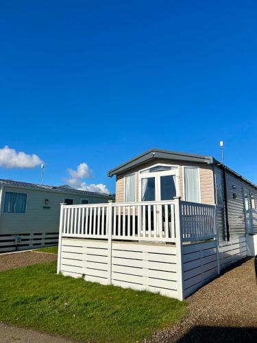 a small house with a white fence in a yard at 2 Bed-Sleeps 6-Patio-Parking-Pet Friendly in Eyemouth