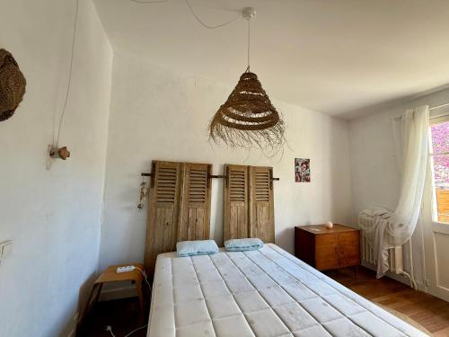 une chambre avec un lit et un lustre dans l'établissement Maison vintage proche forêt avec parking, animaux acceptés - FR-1-652-15, à Saint-Jean-de-Monts