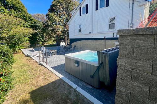 a hot tub in a yard next to a house at Walk to Beach Maine Home with Hot Tub and Deck! in Old Orchard Beach